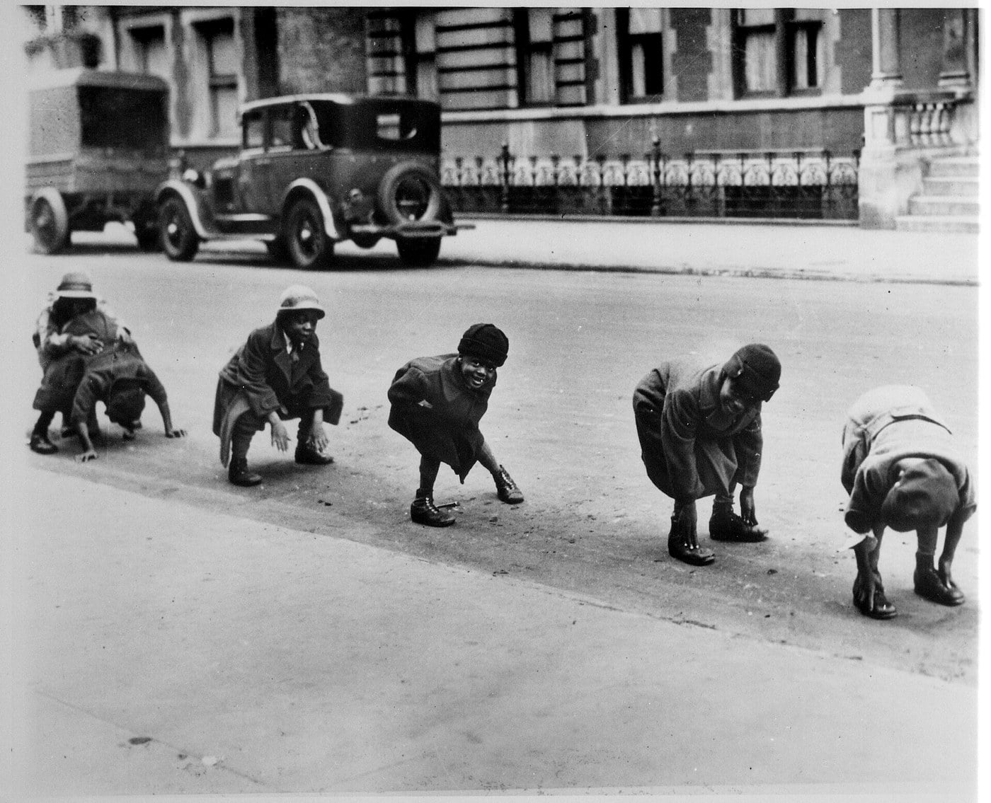 Children playing leapfrog in a city street, 1930s